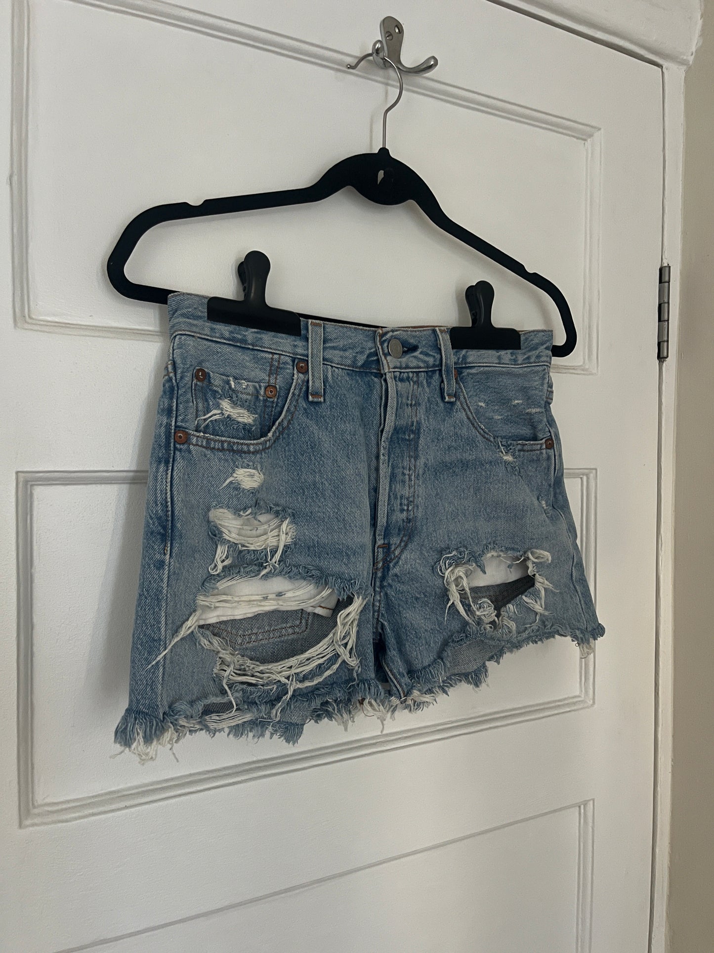 Pair of distressed denim shorts on a white background