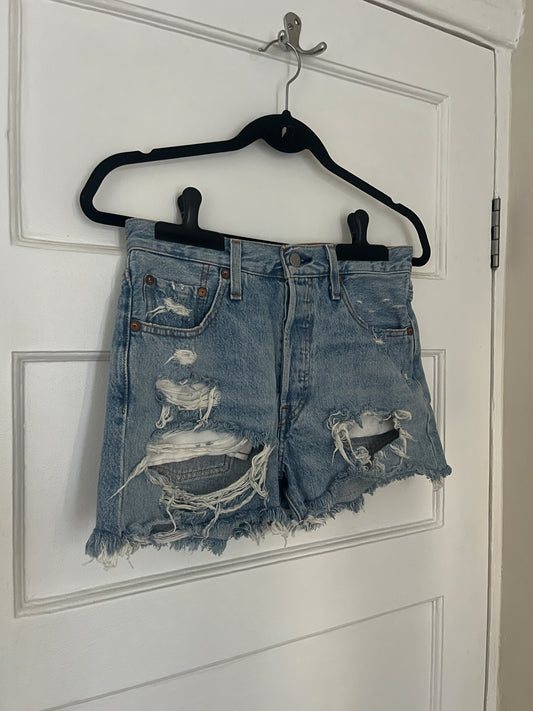 Pair of distressed denim shorts on a white background